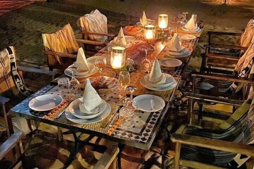 An outdoor dining setup with tables, chairs, and candles. 4