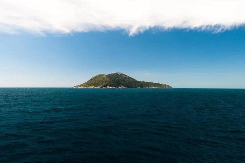 A small island with a clear sky and calm sea. 4