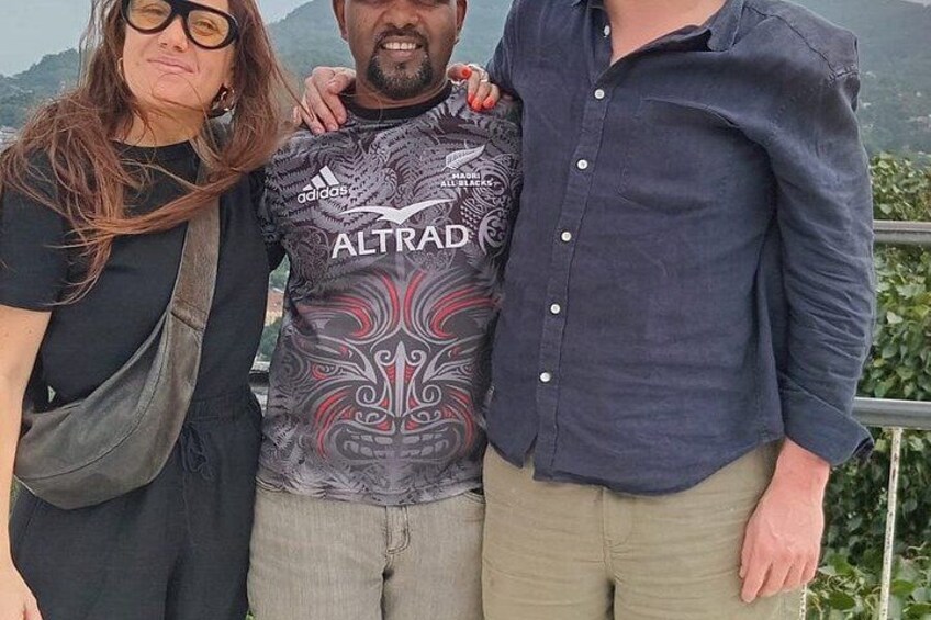 Three people standing together, one wearing a patterned shirt, another in a dark shirt, and the third in a light shirt. 4