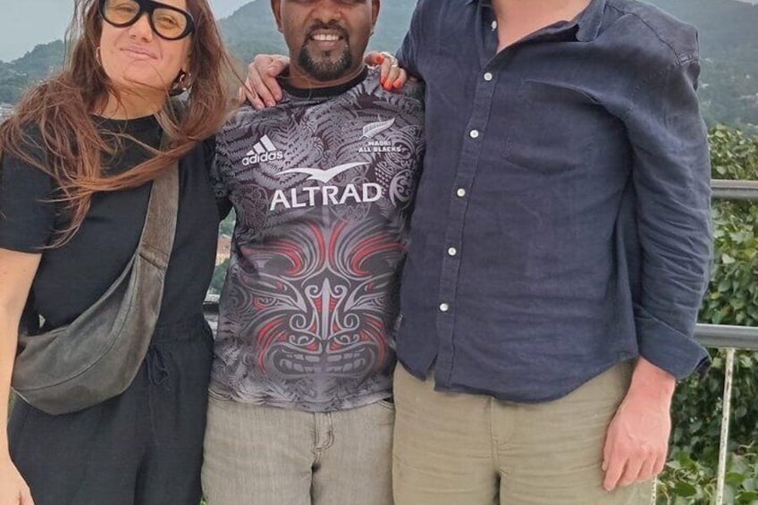 Three people standing together with a mountainous landscape in the background. 4