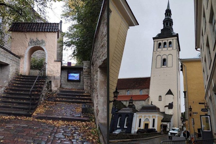A cobblestone street, a church with a tall bell tower, and a stone archway. 5