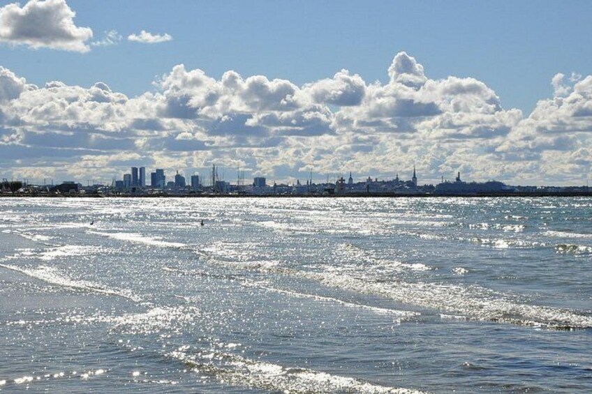 A city skyline across a body of water with sunlight reflecting off the surface. 2