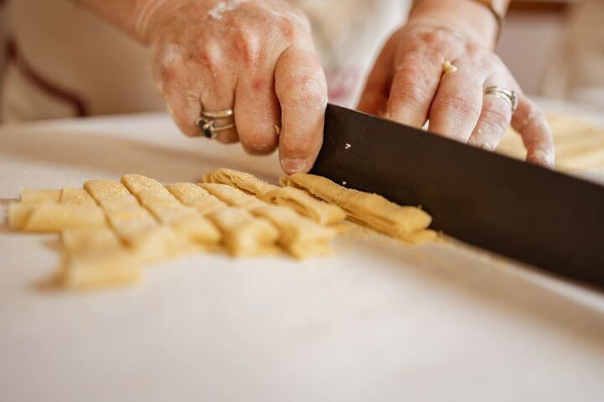 Hands cutting a baguette into pieces. 3