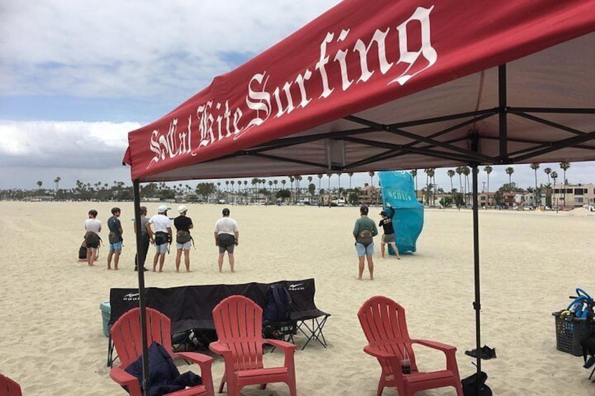 A beach with a red canopy labeled 'Surfing' and several red chairs. 4