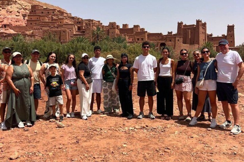 A group of people standing in a desert with ancient ruins in the background. 5