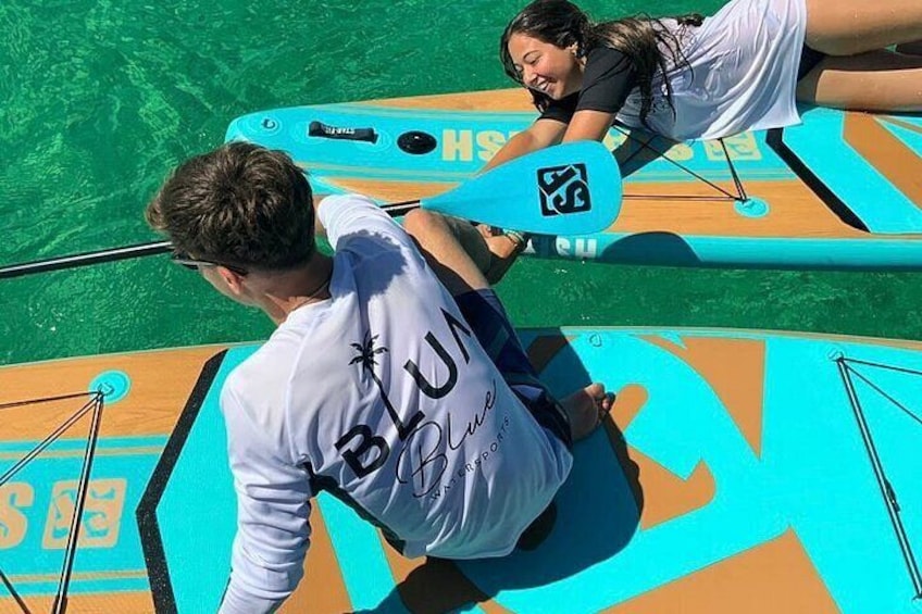 Two people on a paddleboard in a body of water. 2