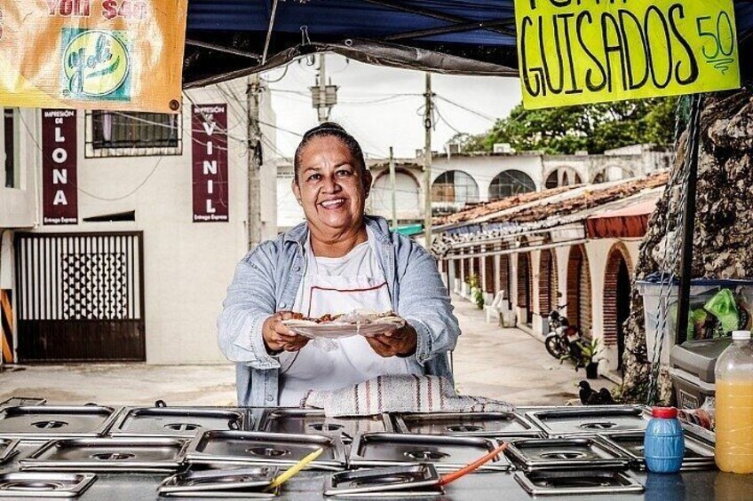 A street food vendor with a sign that reads 'Guisados 50'. 2