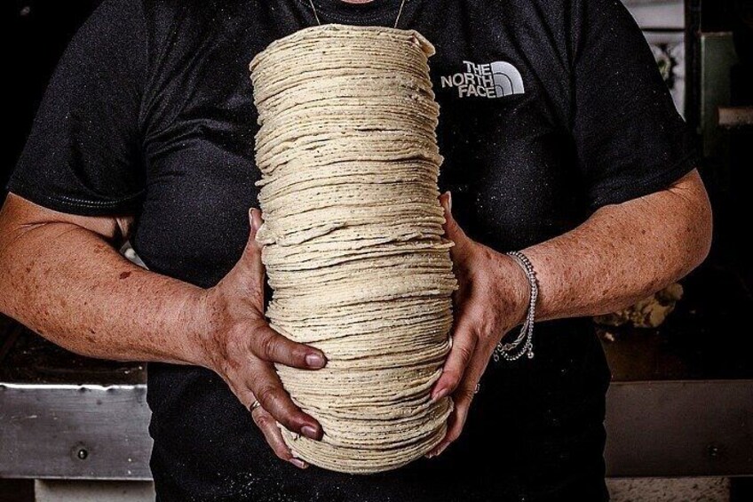 A person holding a large, cylindrical bundle of rope. 5