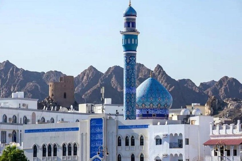 A mosque with a tall minaret and a dome, set against a mountainous backdrop. 5