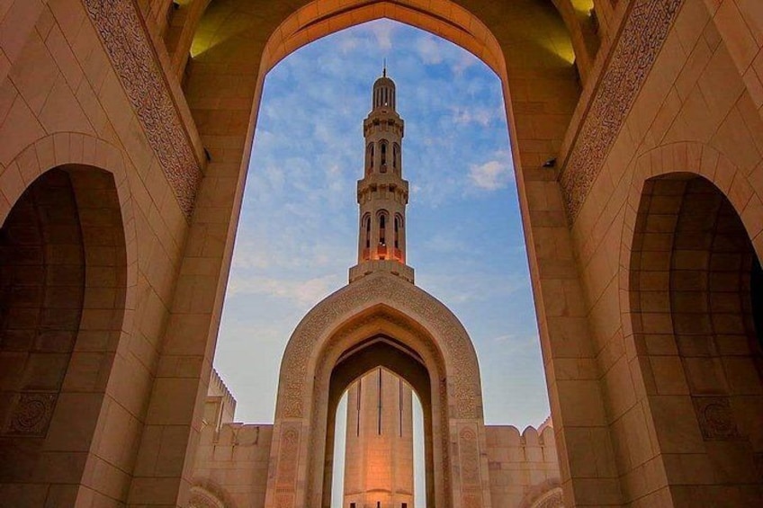 A mosque with a tall minaret, arches, and a clear sky. 4