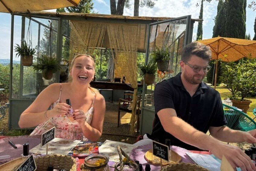 Deux personnes se trouvent sur un marché en plein air, devant des tables où sont exposés divers articles. 1
