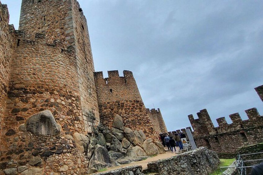 Un castillo de piedra con almenas y un foso. 1