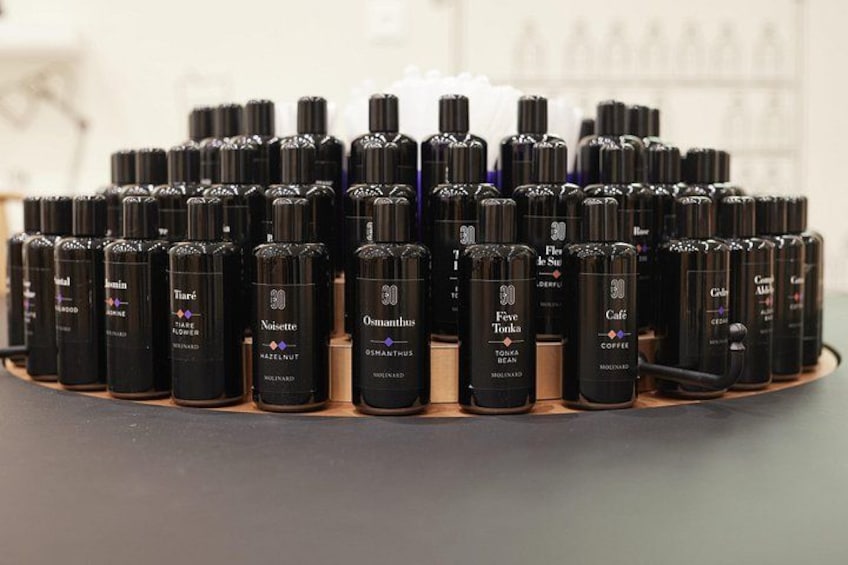 A display of black bottles with labels on a wooden surface. 1