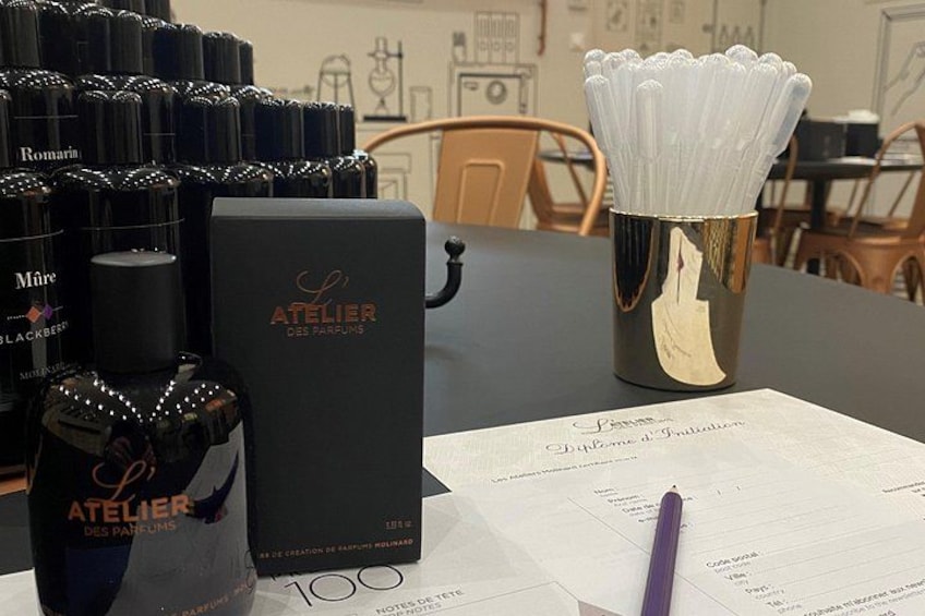 A table with perfume bottles, a box, a menu, and a pen. 2