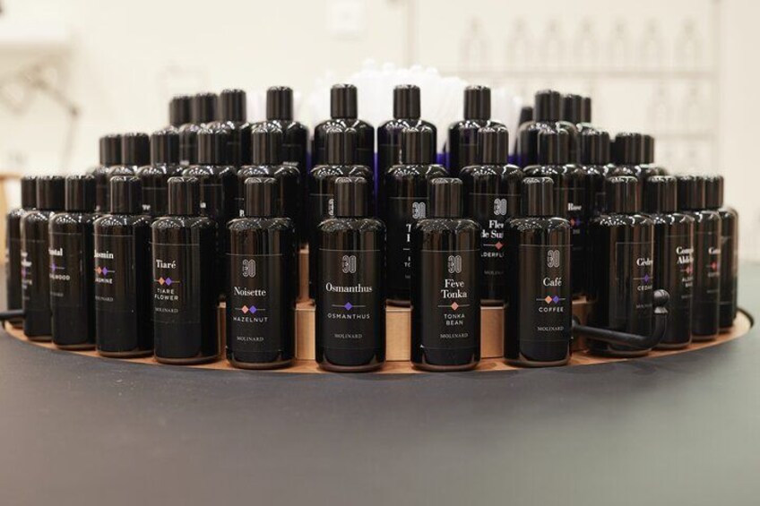 A display of black bottles with labels on a wooden surface. 1