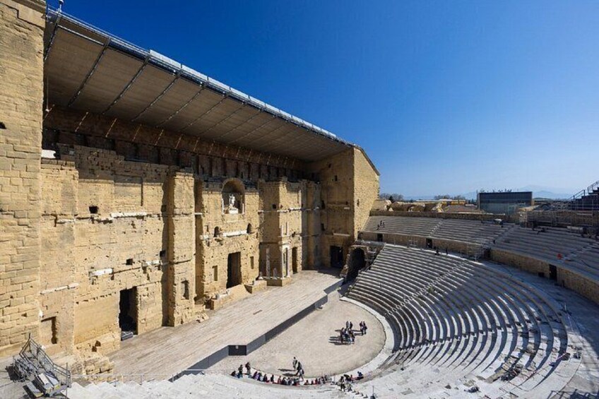 An ancient amphitheater with tiered seating and a central stage area. 2
