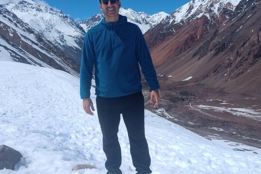 A person standing on a snow-covered mountain with a clear sky. 3