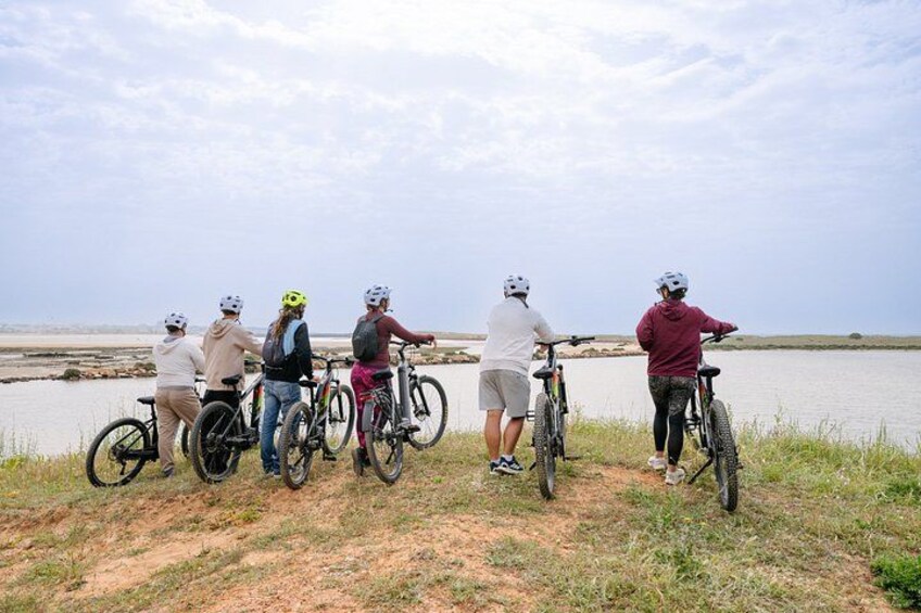 A group of people on bicycles by a lake. 2