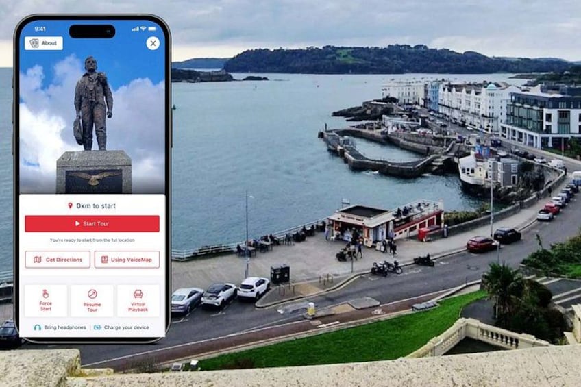 A smartphone displaying a tour app with a coastal town view. 1