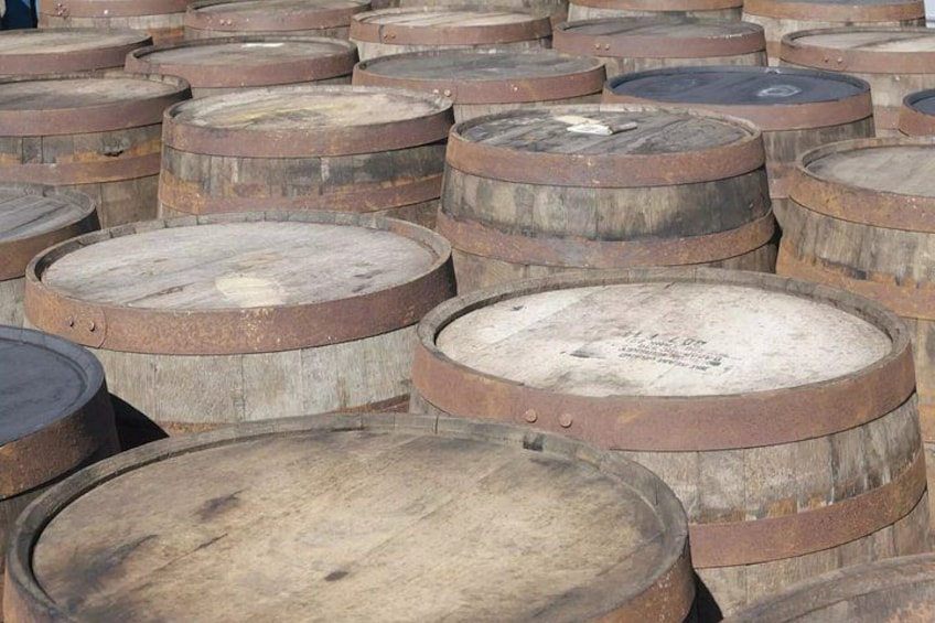 A collection of large, rusted wooden barrels. 3