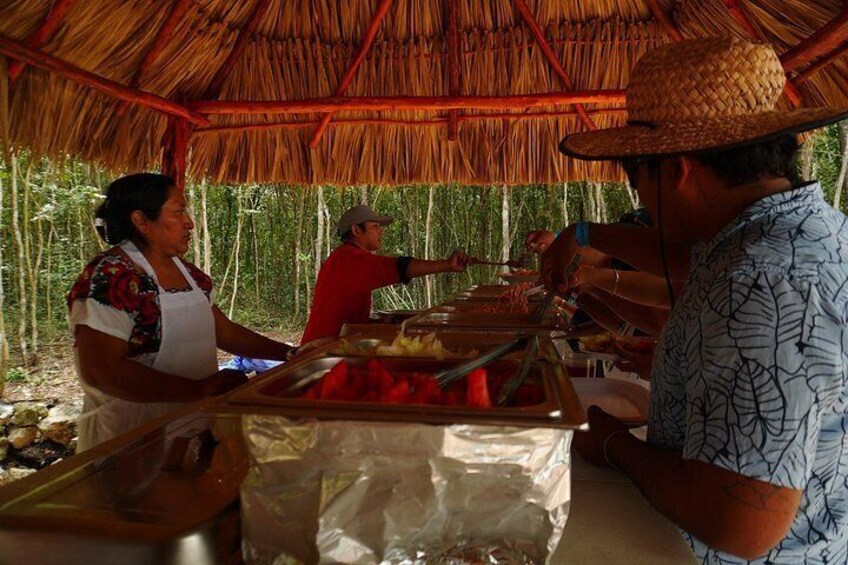 A food stall with a thatched roof, a person serving food, and another person standing nearby. 4