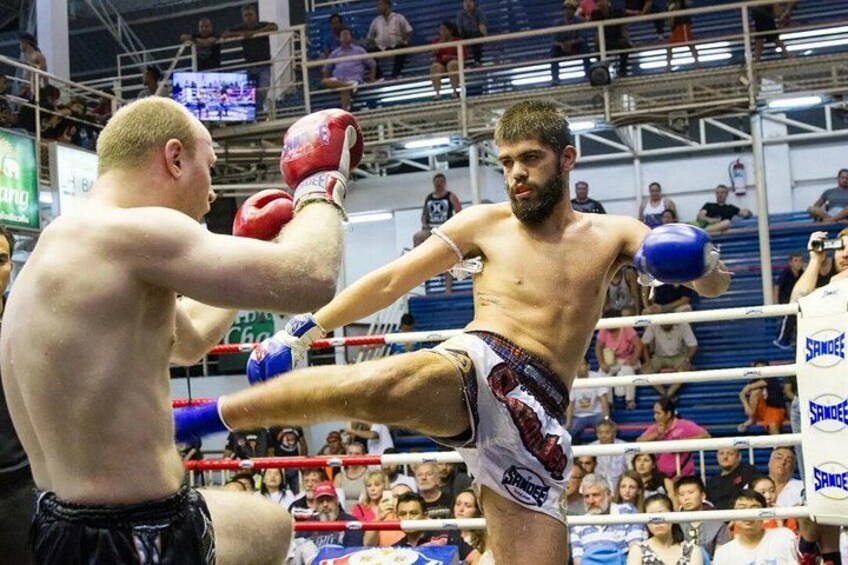 Ein laufender Boxkampf: ein Boxer wirft einen Haken, im Hintergrund sitzt ein Publikum, und eine Boxarena ist zu sehen. 5