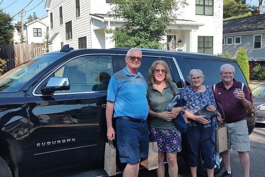 A black SUV with the brand name 'SUBURBAN' parked on a street. 4