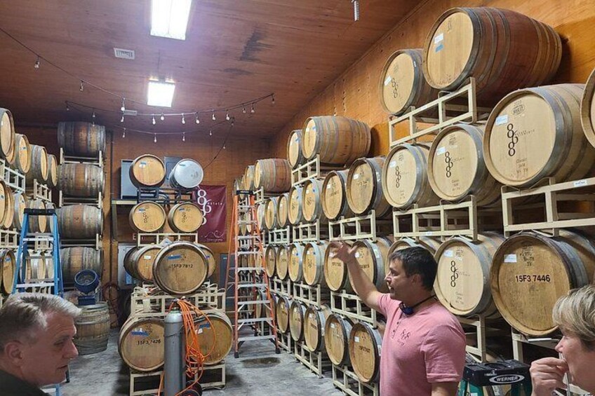A cellar with wooden barrels stacked on shelves. 3