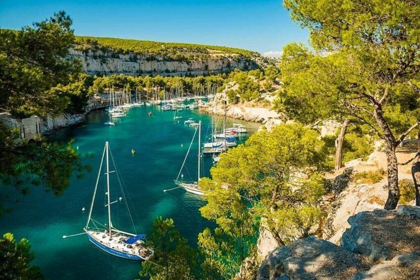 Une baie côtière bordée de bateaux, de falaises et d’une végétation luxuriante. 1