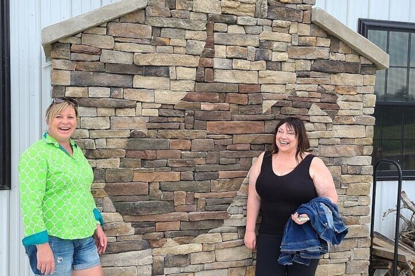 Two people standing in front of a stone wall. 5