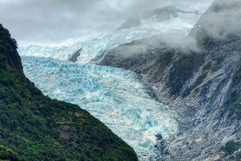 A glacier with steep cliffs and dense vegetation. 2