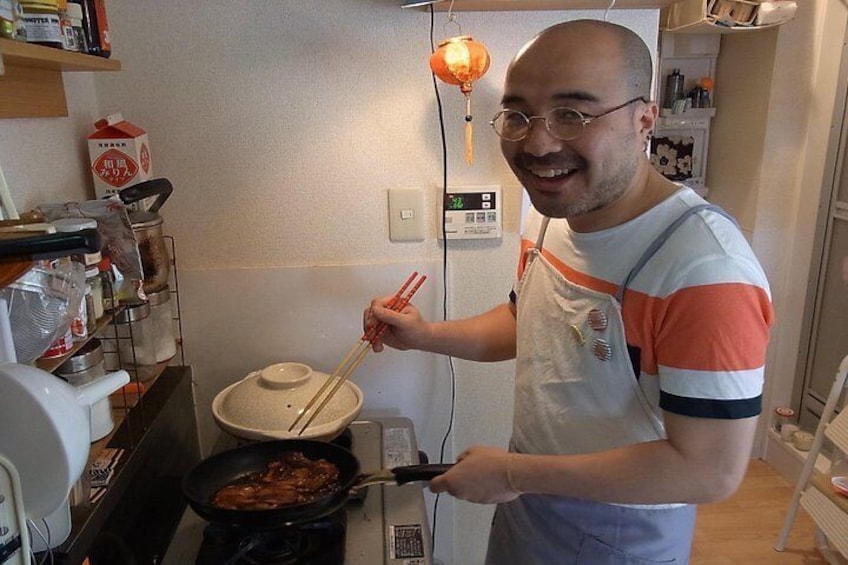 Una persona cocinando en una cocina con estufa, sartén y olla sobre la encimera. 1