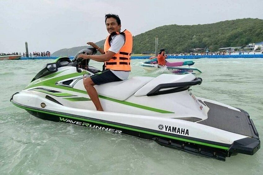 A person riding a Yamaha wave runner jet ski on water. 4