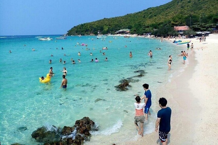 A beach with people swimming and walking along the shore. 2