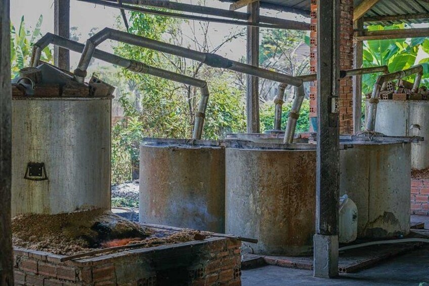 Equipamiento industrial, incluyendo tanques metálicos y tuberías, en un entorno exterior con vegetación de fondo. 3