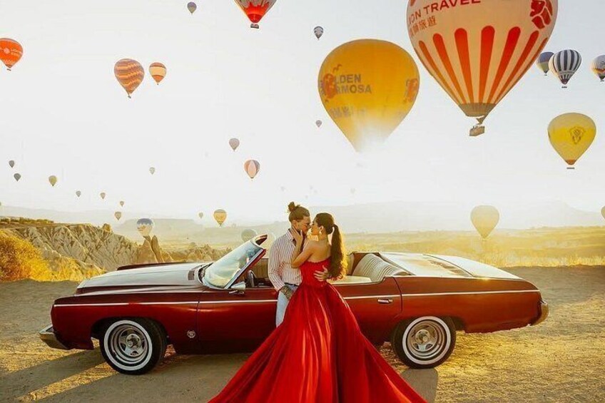 A vintage car, a couple embracing, and hot air balloons in a desert landscape. 3