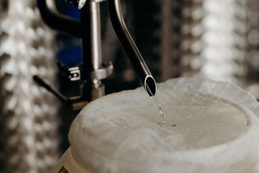 A close-up of a water spout pouring water onto a white, textured surface. 5