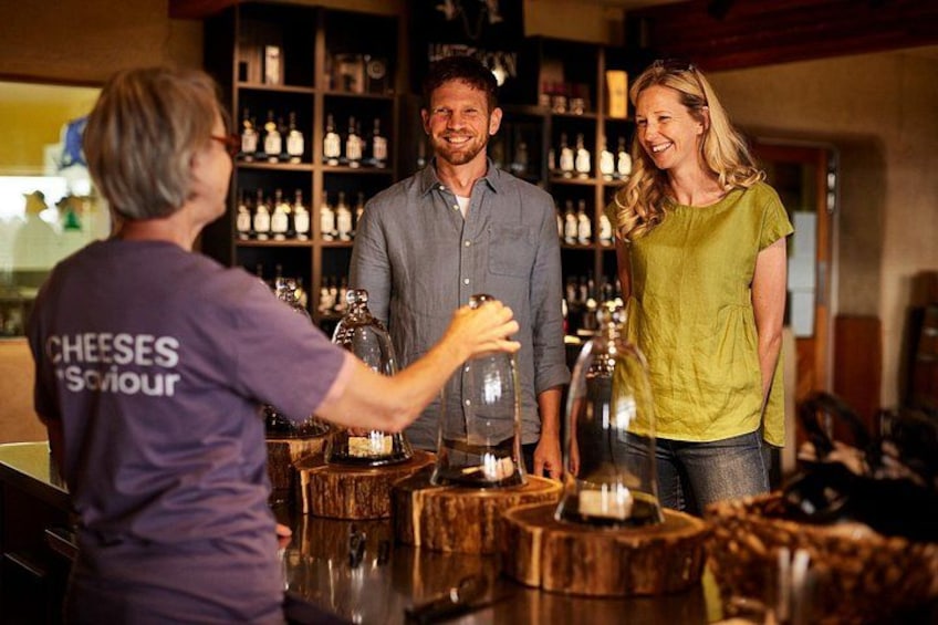 A bar with wooden stools, a bartender, and a customer. 1
