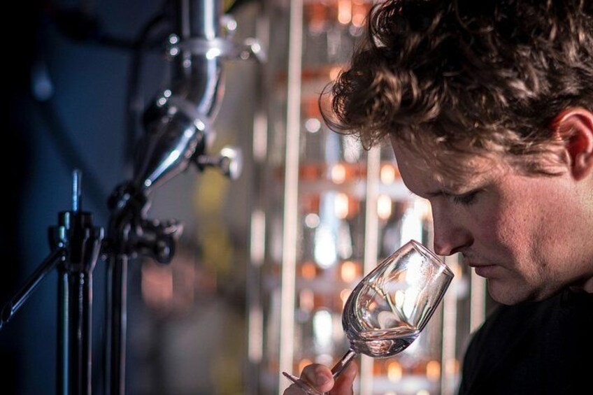 A person holding a wine glass near a bar tap. 4