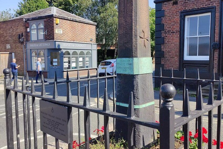 A street scene with a metal fence, a brick building labeled 'SALES & LETTINGS,' and a white car parked nearby. 2