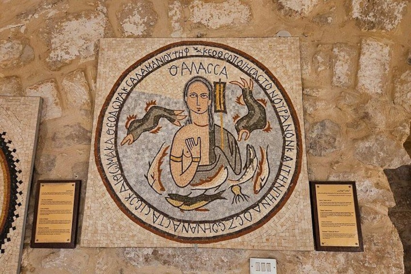 A mosaic with a central figure surrounded by text and decorative elements. 1