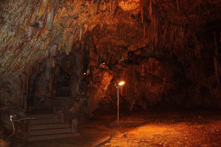 Eine Höhle mit Stalaktiten, einer Lichtquelle und einer Treppe. 2