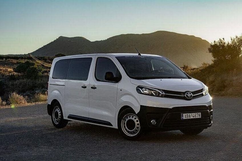 A white van parked on a road with a mountainous background. 3