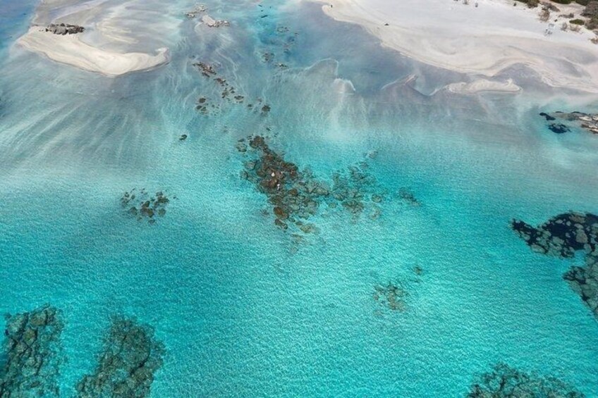 A turquoise sea with coral formations and sandy beaches. 3