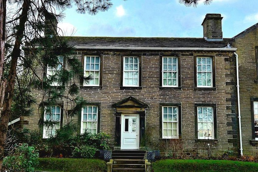 A two-story brick house with a white door and multiple windows. 3