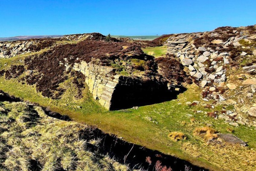 A stone bridge over a river, surrounded by grassy terrain and rocky outcrops. 4