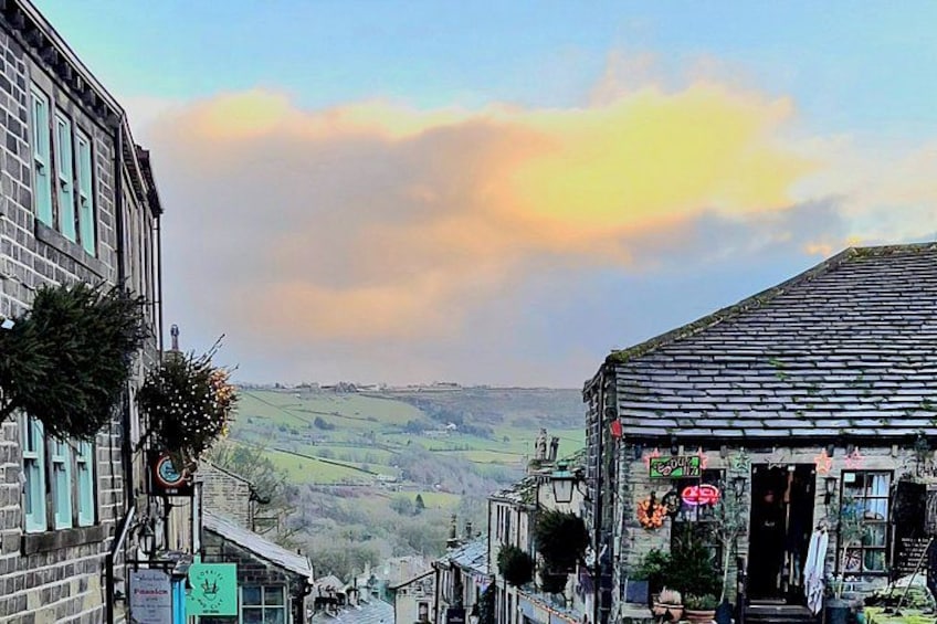 A town with buildings, a signboard, and a view of the countryside. 3