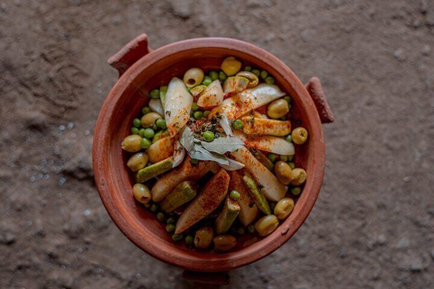 A clay pot filled with vegetables and spices. 4