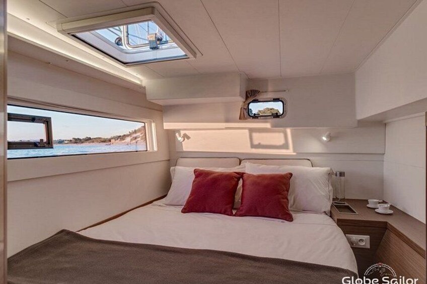 A yacht interior with a bed, a window, and a skylight. 5