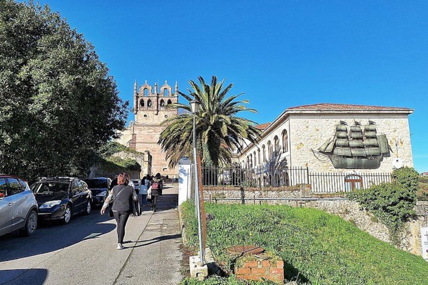 A street with parked cars, pedestrians, a palm tree, and a building with a mural. 2